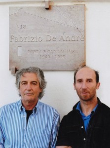 Giuseppe con Salvatore sotto la targa “Via Fabrizio De Andrè”, leggermente abbrunita in laboratorio, per migliore visibilità della scritta